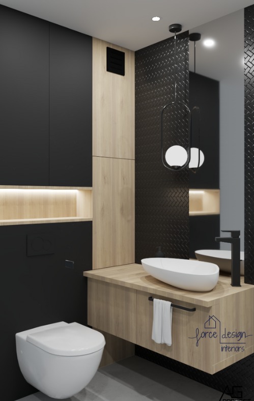 Nowoczesna łazienka z czarnymi ścianami i drewnianymi akcentami, wisząca misa WC, umywalka nablatowa w kształcie łzy, czarna armatura i lampa wisząca z dwoma białymi kulami.