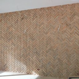 WYKOŃCZENIE WNĘTRZ DENYS POLTAVETS - Ściana wyłożona cegiełkami w jodełkę, widoczne przewody i fragment ściany z płyt gipsowo-kartonowych przed wykończeniem.