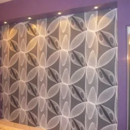 Ściana w pokoju z fioletowymi ścianami i czarno-białą tapetą o geometrycznym wzorze, oświetlona punktowymi lampami sufitowymi.