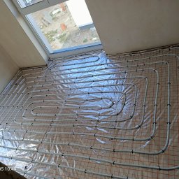 KRIOTTECH - Białe rury ogrzewania podłogowego ułożone na folii z siatką w Słupsku przed wylaniem posadzki.