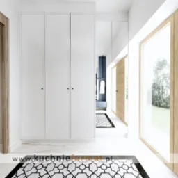 Nowoczesny przedpokój z białymi szafami, lustrem w zabudowie i drewnianymi panelami ściennymi, uzupełniony marmurową podłogą z geometrycznym wzorem dywanu.