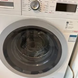 Pralka Bosch HomeProfessional z panelem sterowania pokazującym różne programy prania, widoczne logo Bosch na drzwiczkach i obudowie, certyfikat ECARF Quality Tested.