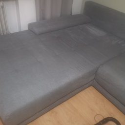 Pucyk - Szara kanapa narożna z widocznymi śladami czyszczenia i urządzeniem do prania tapicerki leżącym na podłodze.