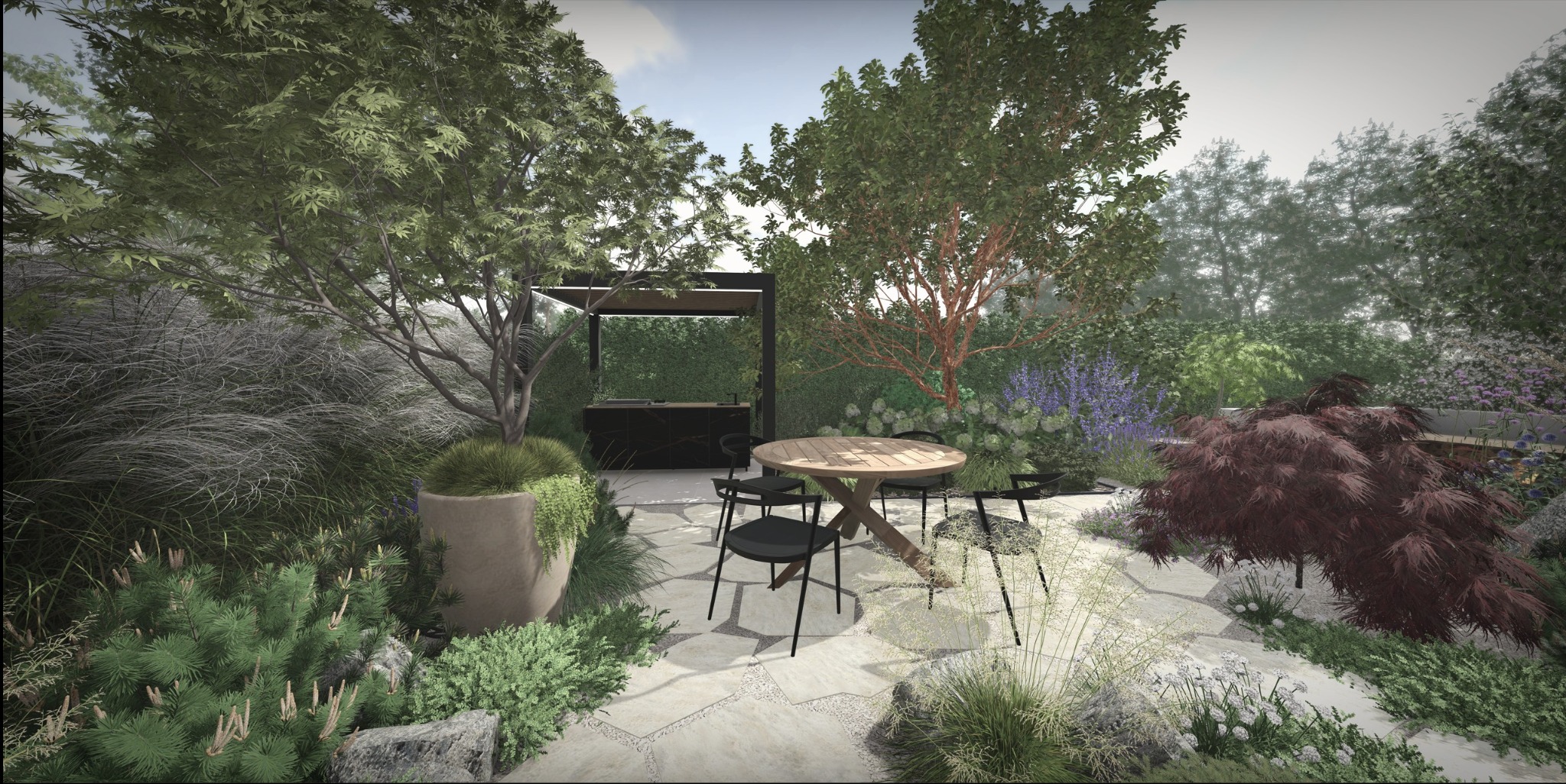 Aranżacja ogrodu z okrągłym stołem i czarnymi krzesłami na kamiennej nawierzchni. W tle roślinność, drzewa i zabudowa grillowa.