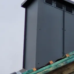 Metalowa obudowa komina z wentylacją, zamontowana na dachu, widoczne drewniane elementy konstrukcji dachowej.