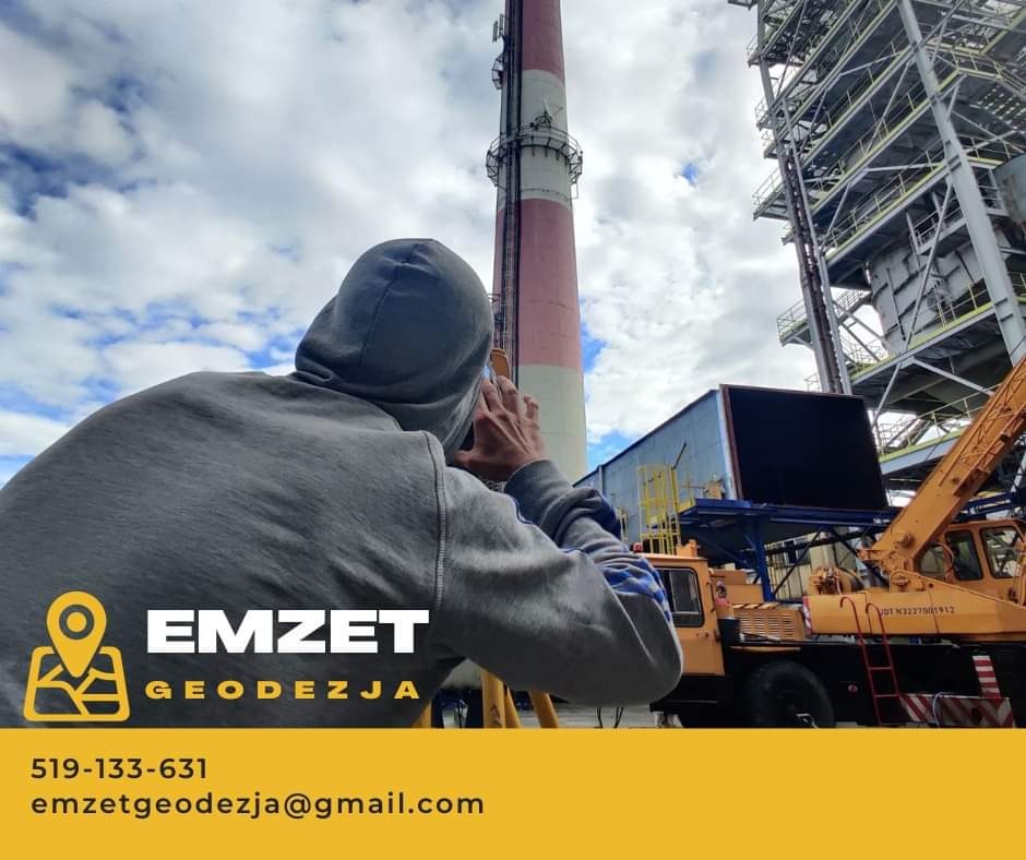 Mężczyzna w szarej bluzie z kapturem, wykonujący pomiary geodezyjne na tle wysokiego komina i konstrukcji przemysłowej, z widocznym dźwigiem i logo firmy EMZET GEODEZJA.