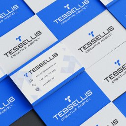 Nouva Atelier - Marta Lińska - Stos wizytówek firmy Tessellis Creative Agency w kolorach bieli i kobaltu, z widocznymi danymi kontaktowymi na jednej z nich. Układ diagonalny, ostre światło.