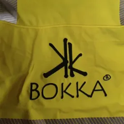 Żółta kurtka robocza z odblaskowymi pasami i czarnym logo BOKKA na plecach.