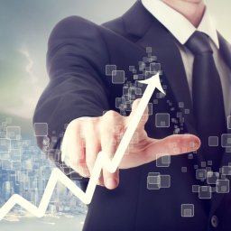 Mateos Acess Financial Inter Country - Mężczyzna w garniturze dotyka palcem wirtualnego wykresu wzrostu na tle panoramy miasta, symbolizującego postęp finansowy.