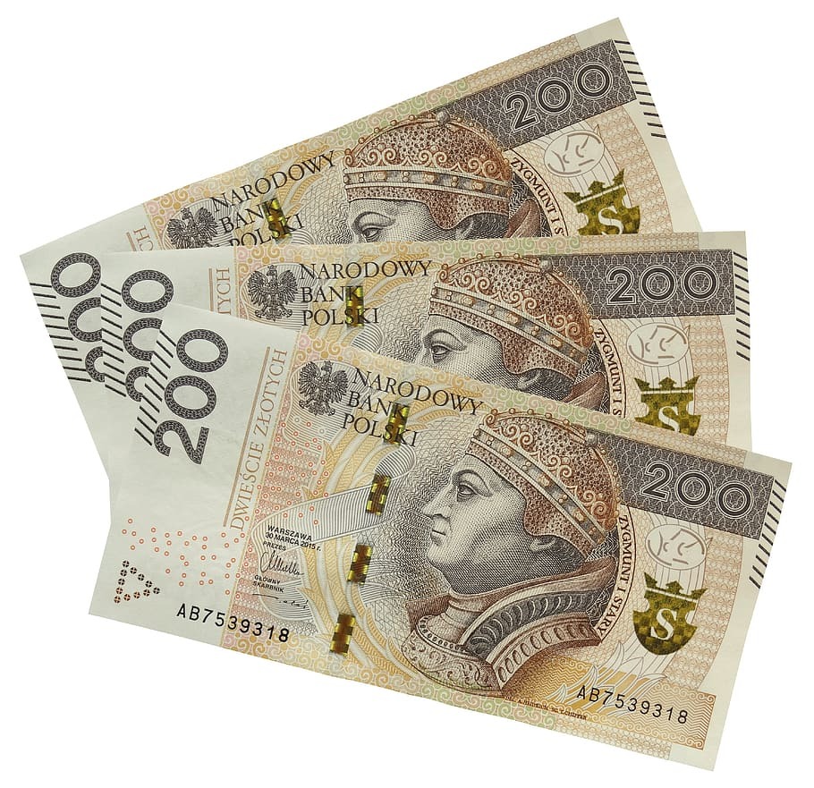 Trzy banknoty 200 zł ułożone ukośnie na białym tle, widoczne portrety Zygmunta I Starego i numery seryjne AB7539318.