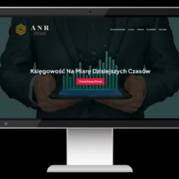 Ekran monitora wyświetla stronę internetową biura rachunkowego ANR z hasłem 'Księgowość Na Miarę Dzisiejszych Czasów' i wizualizacją danych statystycznych, trzymaną w dłoniach osoby w garniturze.