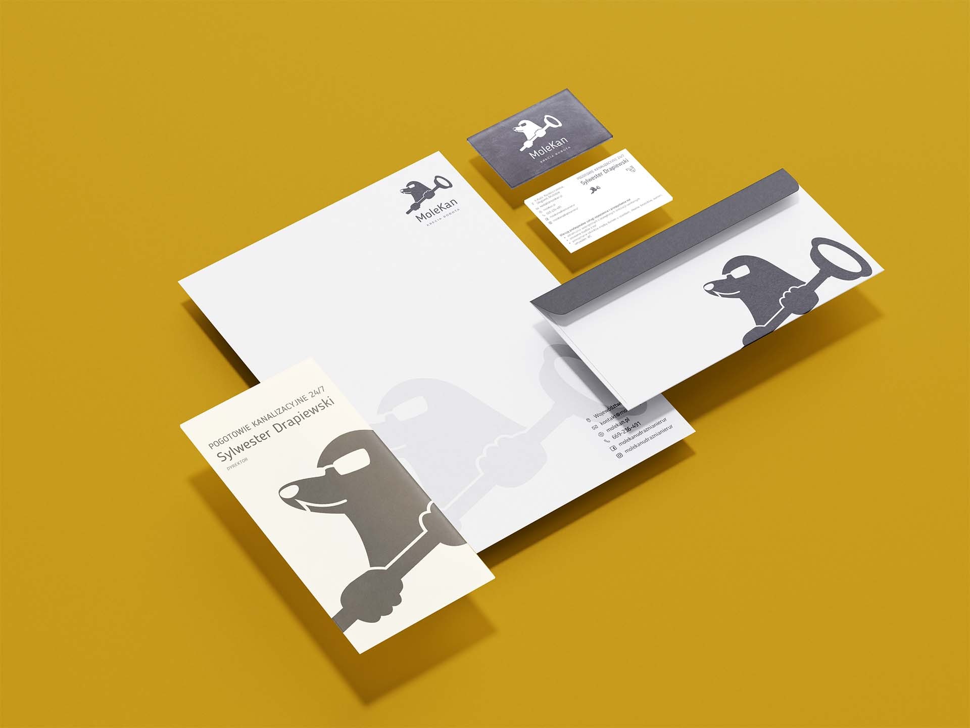 Zestaw identyfikacji wizualnej firmy MoleKan na żółtym tle: wizytówka, papier firmowy, koperta, ulotka, prezentujący logo z kretem trzymającym klucz francuski.