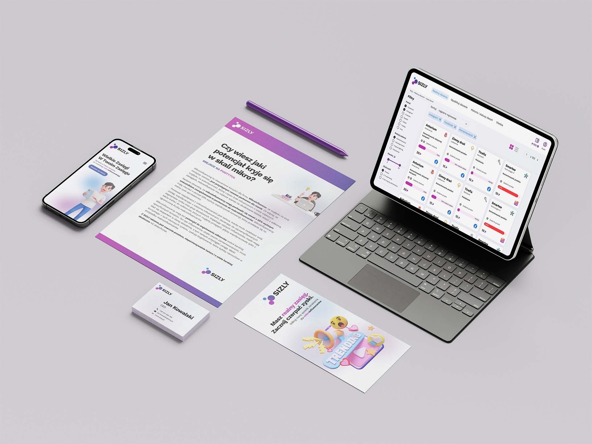 Tablet z otwartą aplikacją analityczną SIZLY, smartfon z wyświetloną reklamą, ulotka informacyjna, wizytówka, fioletowy rysik i karta z grafiką trendów, wszystko ułożone na jasnym tle.