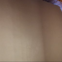 OLIBUD Krzysztof Tomaniak - Świeżo nałożony tynk maszynowy na ścianie poddasza, widoczne drewniane elementy konstrukcji dachu i fragment muru z cegły.