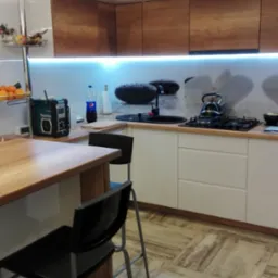 Nowoczesna kuchnia w Obornikach z białymi szafkami górnymi i drewnopodobnymi dolnymi, wyspą z drewnianym blatem i czarnymi hokerami. Na blacie kuchennym czajnik, płyta gazowa i czarny zlew, a...