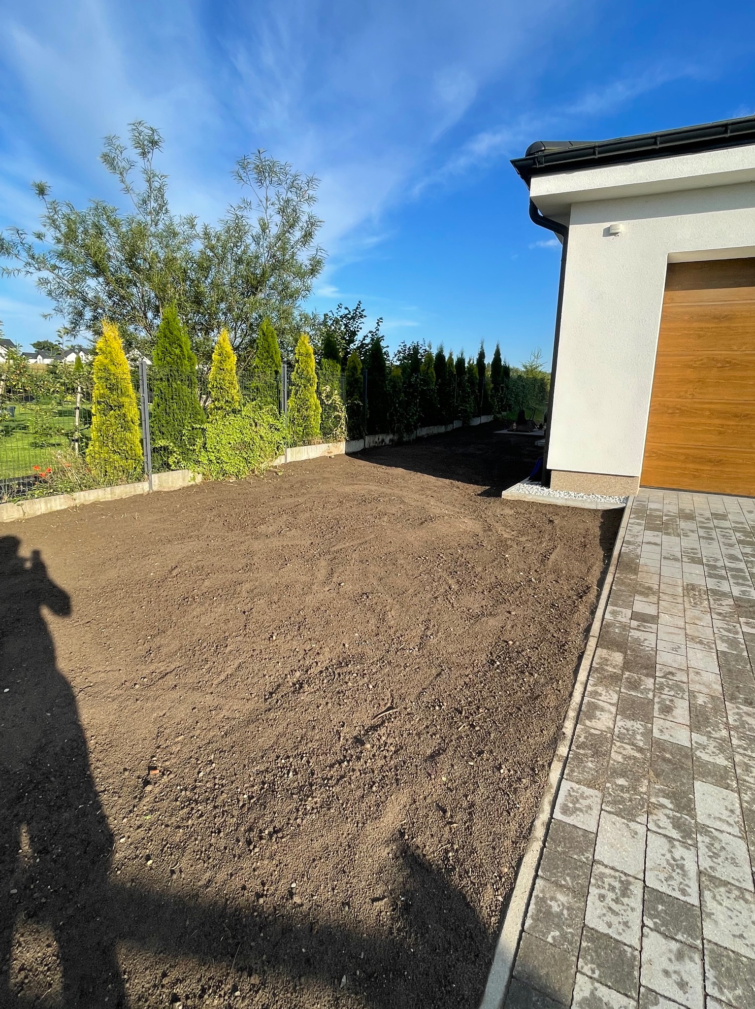 Niwelacja terenu i nasypanie czarnoziemu.