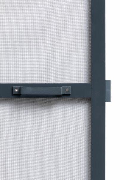 Szczegółowy widok ramy okiennej z siatką i uchwytem w kolorze grafitowym, mocowanym na dwie śruby, z widocznym fragmentem blokady okiennej.