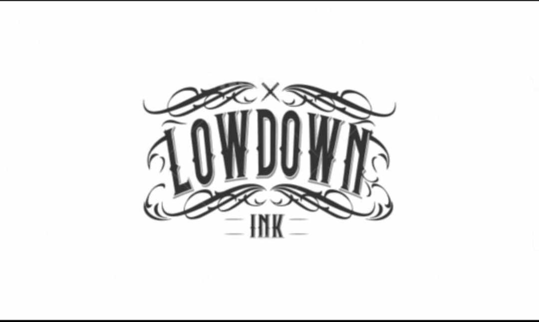 Logo 'LOWDOWN INK' w stylu vintage, z dekoracyjnymi zawijasami i czcionką szeryfową na białym tle.