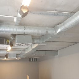 Venteam Sp. z o. o. - Kompleksowy system wentylacji i klimatyzacji w biurze, widoczne kanały wentylacyjne, klimatyzatory i kratki wentylacyjne na suficie z instalacją elektryczną.
