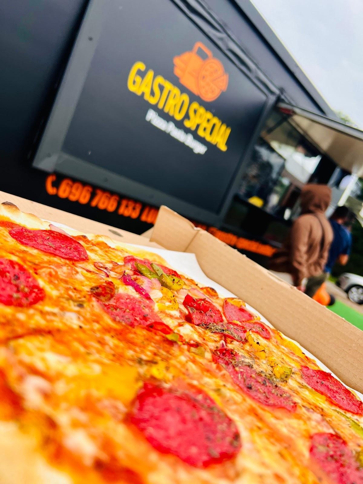 Pizza pepperoni w kartonowym pudełku, z widocznym food truckiem z logo 'Gastro Special' w tle.