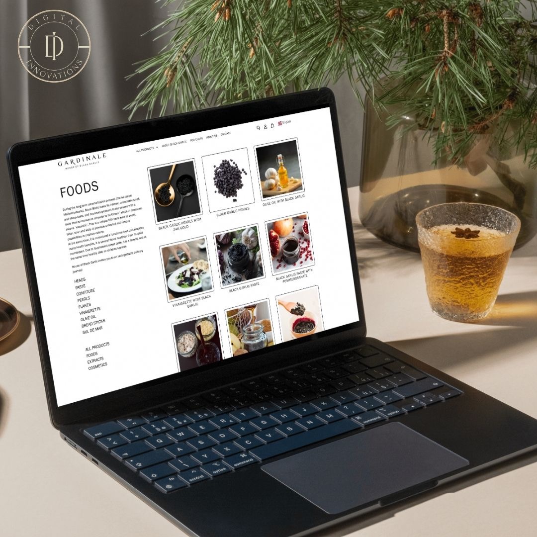 Laptop wyświetla stronę internetową z produktami spożywczymi, w tle szklanka z napojem i gałązka świerku.