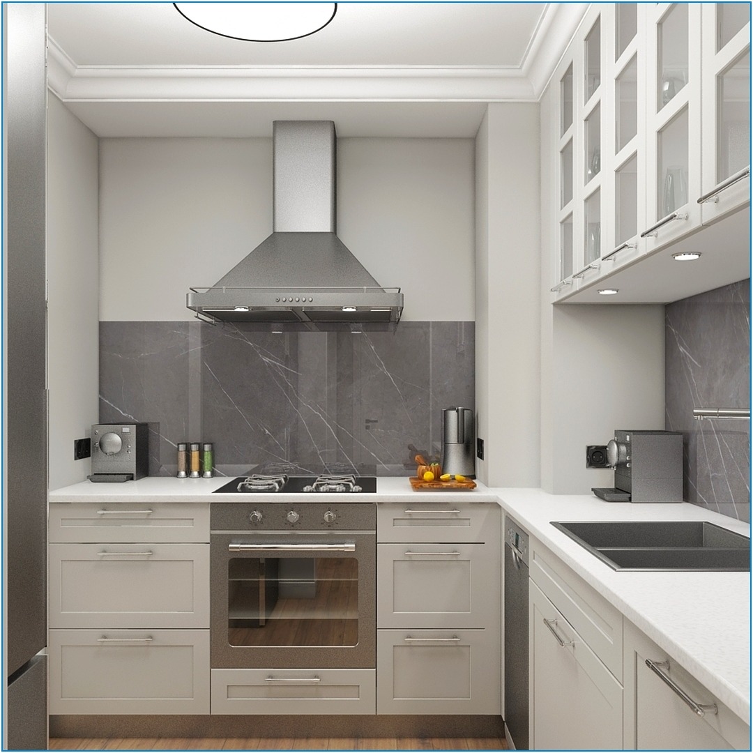 Kompaktowa kuchnia w odcieniach szarości i bieli z blatem roboczym, marmurowym backsplashiem i srebrnym okapem, oświetlona lampą sufitową.