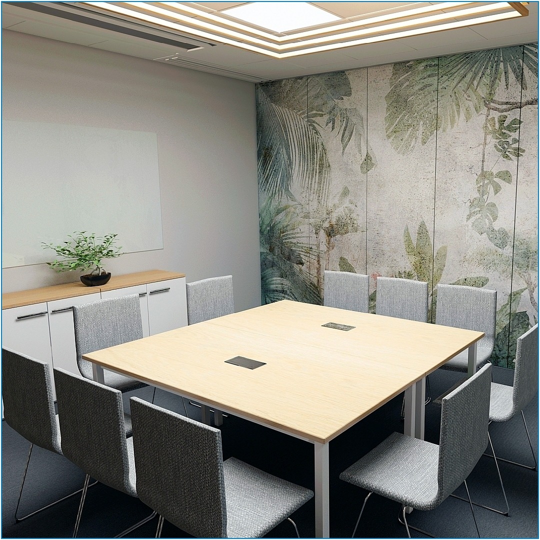 Jasne biuro z kwadratowym stołem konferencyjnym otoczonym ośmioma szarymi krzesłami, ścianą z motywem roślinnym i białymi szafkami z rośliną na blacie.