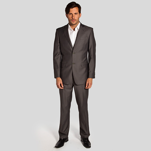 Mężczyzna w szarym garniturze i białej koszuli, pozujący na jasnoszarym tle.