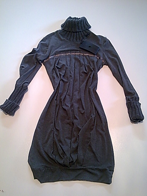 Szara dzianinowa sukienka z długim rękawem i golfem, leżąca na białym tle, z widoczną metką.