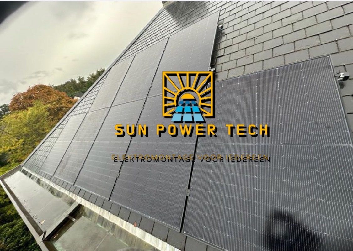 Panele słoneczne na skośnym dachu pokrytym szarymi dachówkami, widok z dołu, logo firmy na pierwszym planie.