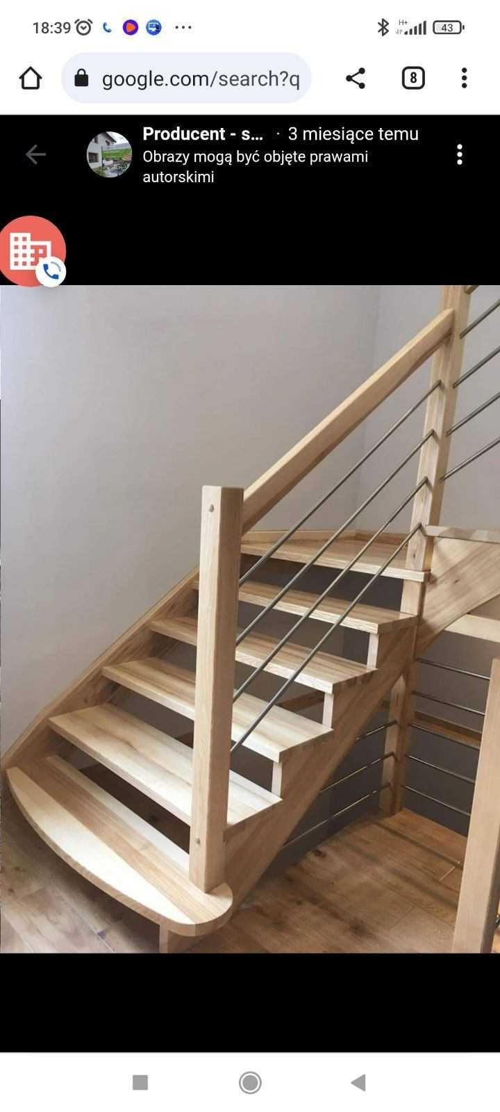 Jasne drewniane schody z metalowymi prętami balustrady, widoczne z dołu, z zaokrąglonym pierwszym stopniem.