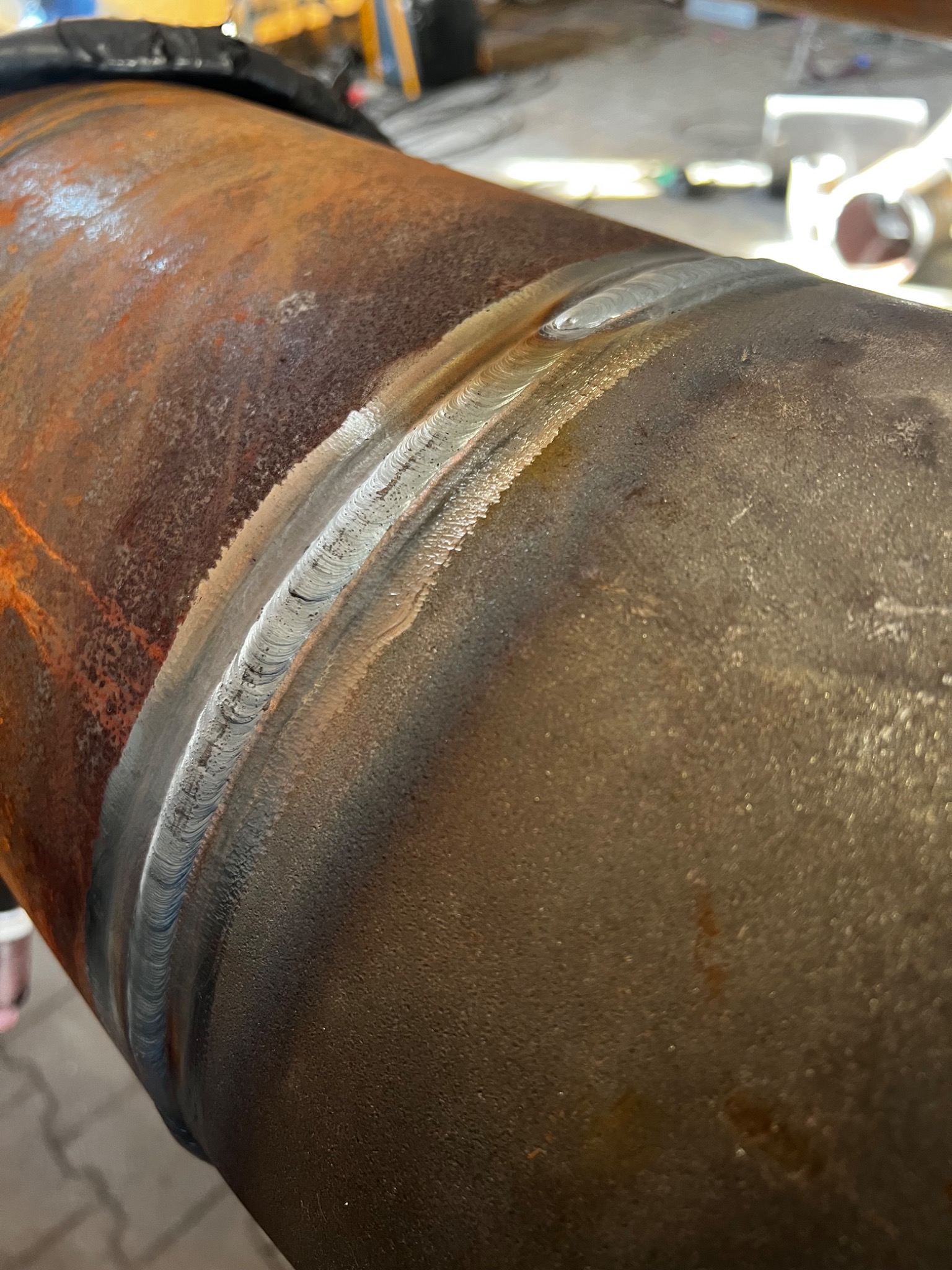 Spoina na rurze ze śladami korozji, widoczna struktura spawu.