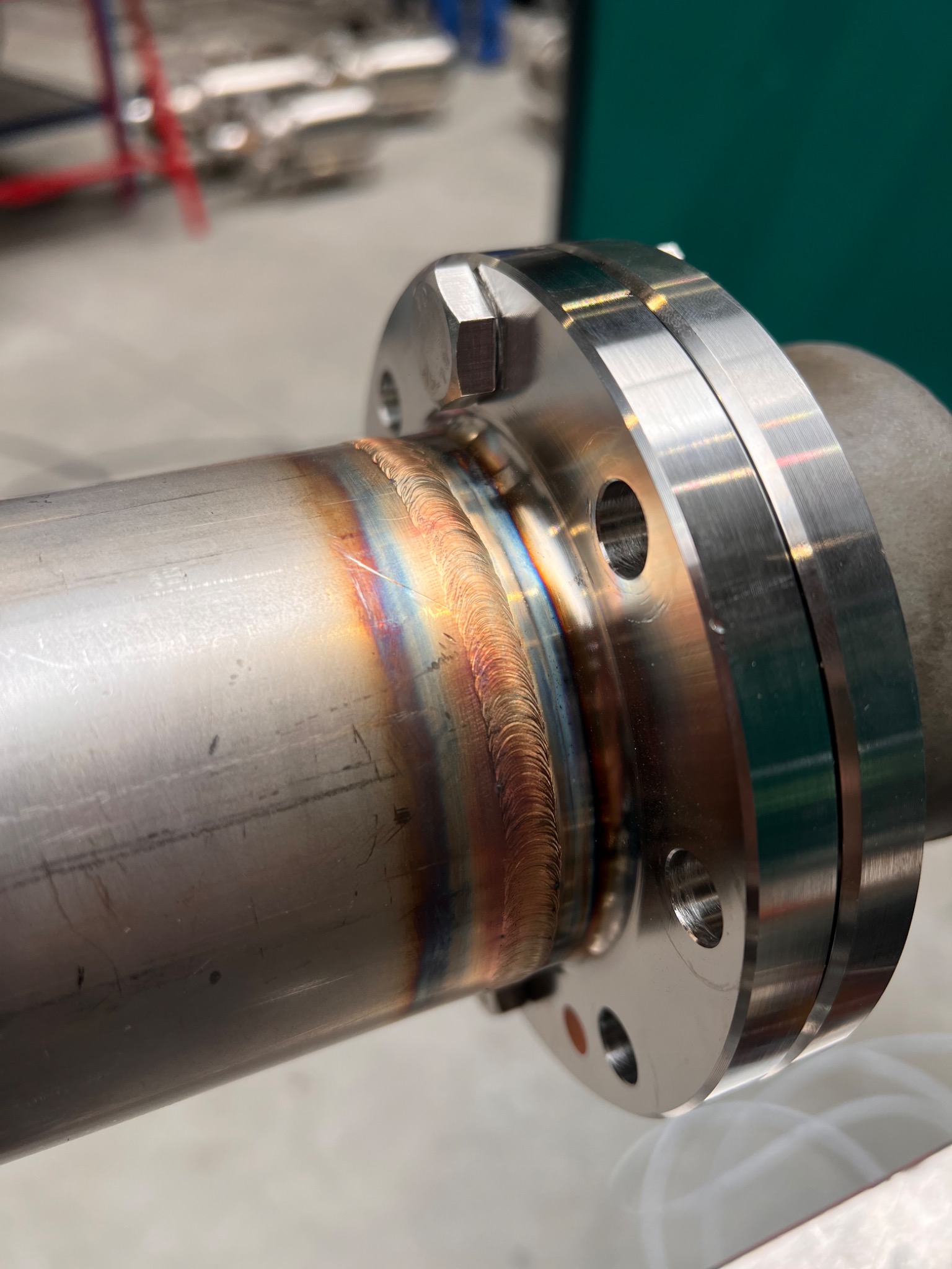 Spoina łącząca rurę ze stalowym kołnierzem, widoczne charakterystyczne przebarwienia termiczne metalu po spawaniu.