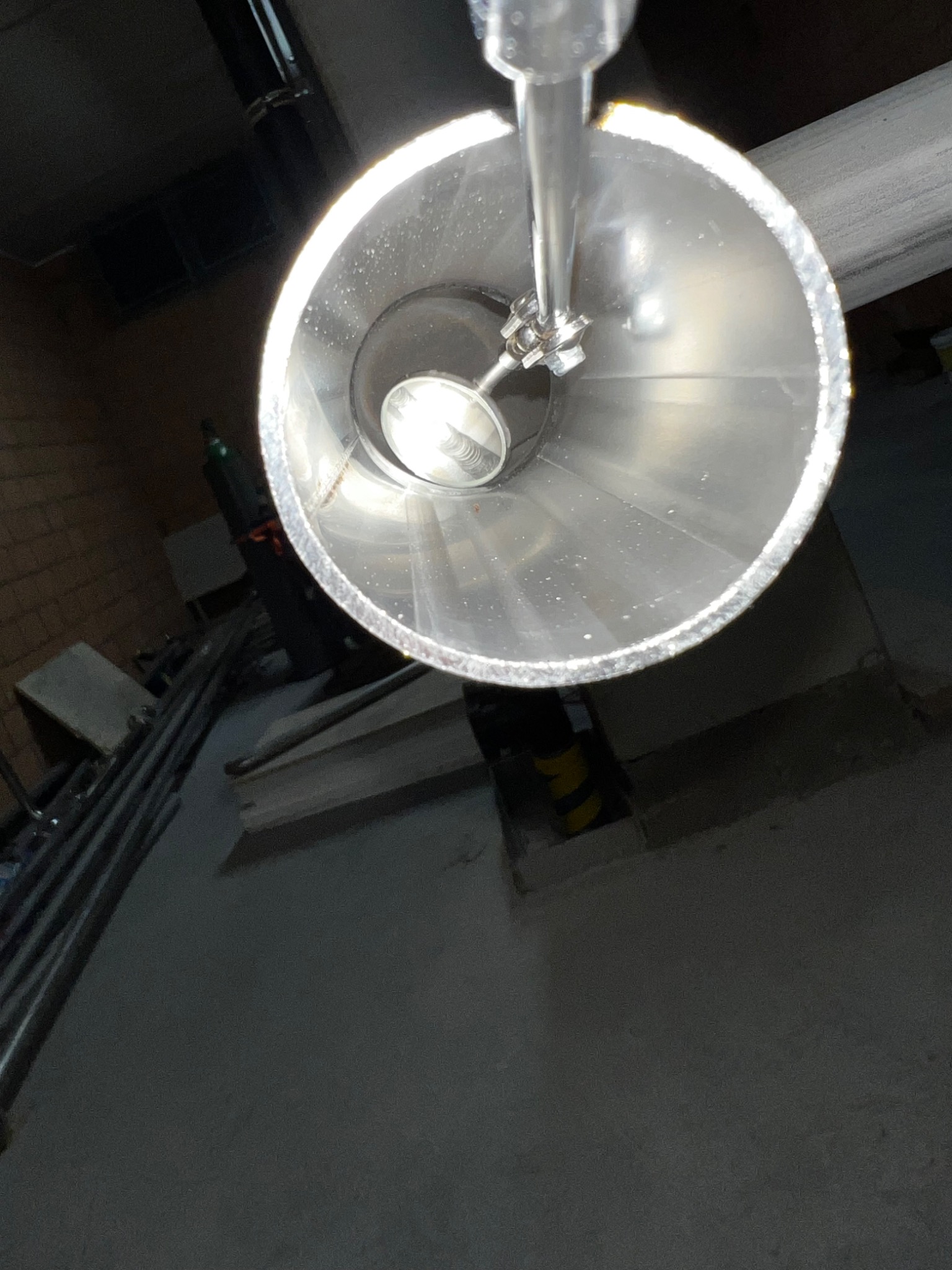 Wnętrze spawanej rury ze stali nierdzewnej, widok z góry, widoczne spawy i elementy mocujące.