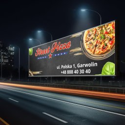 Reflekz Studio - Billboard reklamowy pizzerii Street Pizza nocą, z rozmazanymi światłami samochodów na autostradzie. W tle budynki miejskie i latarnie uliczne.
