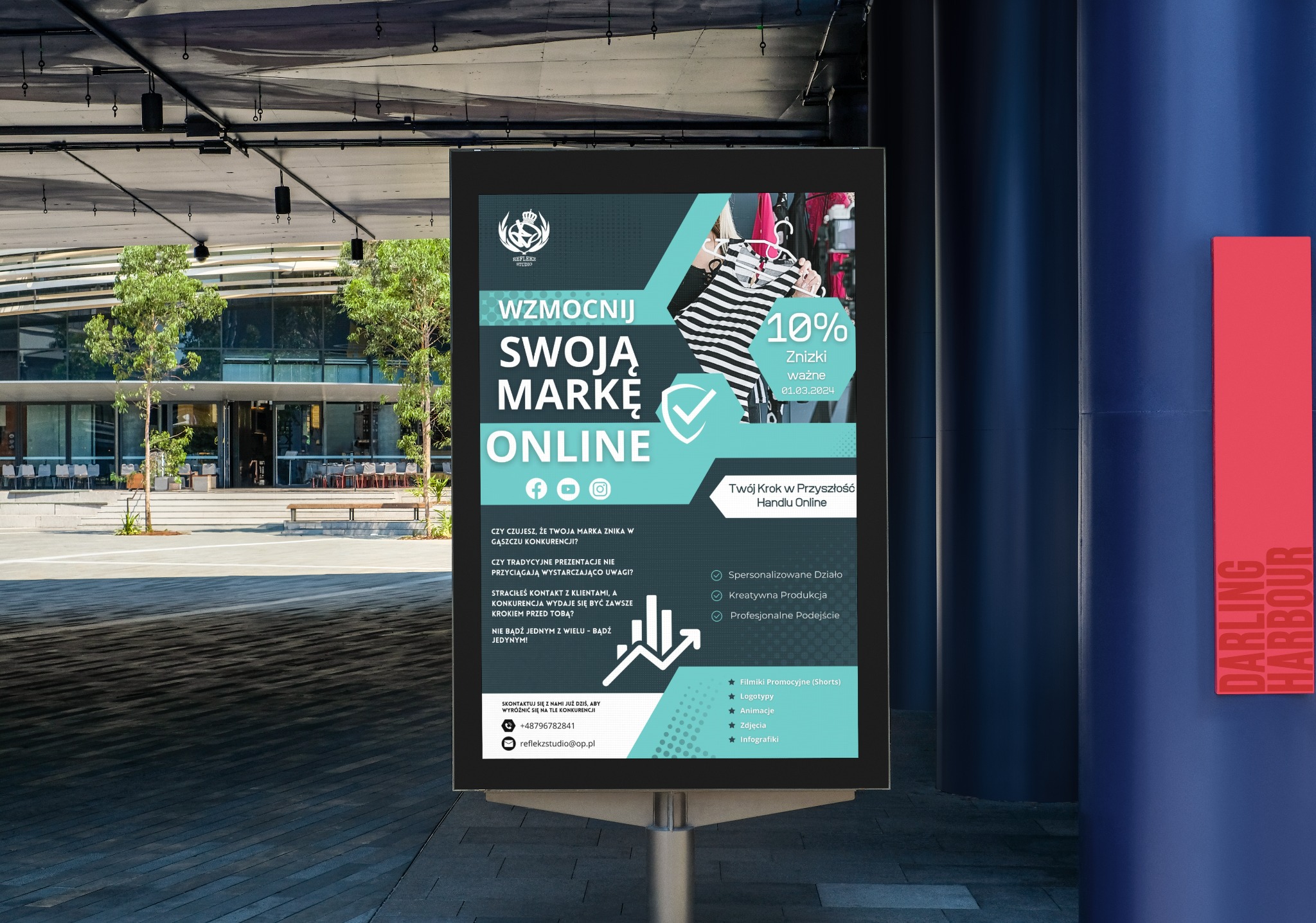 Billboard reklamowy z hasłem 'Wzmocnij swoją markę online', prezentujący ofertę agencji marketingowej z wizualizacjami ubrań i informacją o 10% zniżce, umieszczony na zewnątrz budynku w przestrzeni...