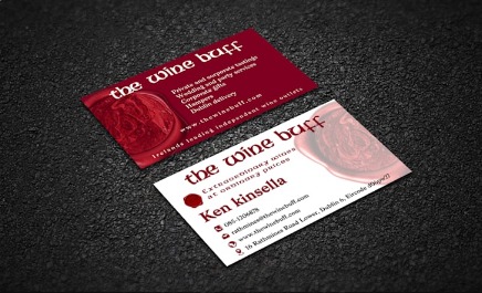 Dwie wizytówki firmy z Ostrowca Świętokrzyskiego, z motywem wina, leżące na czarnym, teksturowanym tle. Jedna w kolorze bordowym, druga biała z bordowymi akcentami, obie z logo firmy.