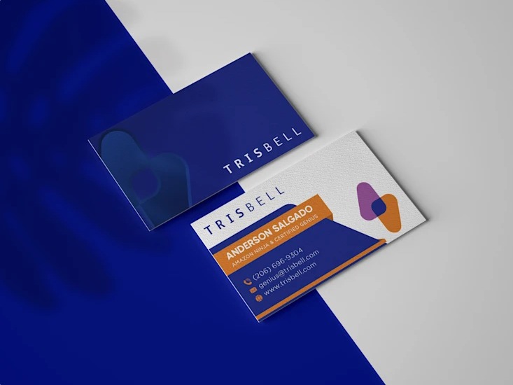 Dwie wizytówki firmy Trisbell leżące na dwukolorowym tle, jedna z pełnym logo, druga z danymi kontaktowymi Andersona Salgado, Amazon Ninja & Certified Genius.