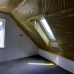 Usługi remontow Budowlane Leszek Wiśniewski - Poddasze z oknem dachowym w trakcie ocieplania, folia paroizolacyjna zabezpiecza skośny sufit. Widoczne trzy otwory na gniazdka elektryczne.