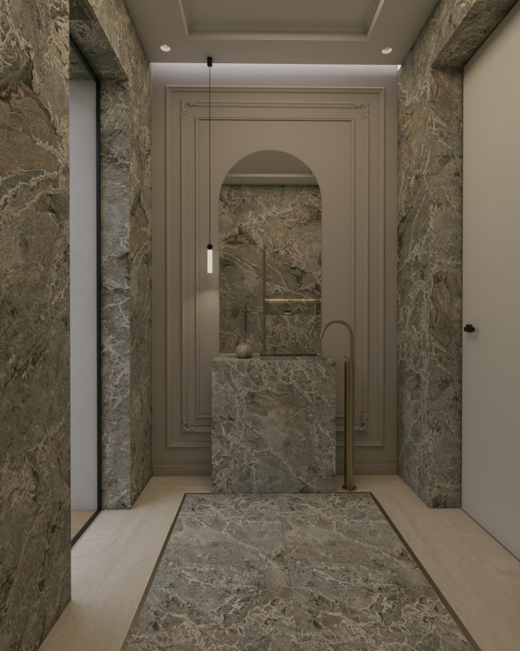 Luksusowa łazienka z marmurowymi ścianami, podłogą i umywalką. Złota armatura i ozdobne listwy dodają elegancji wnętrzu. Nad umywalką wisi lustro w kształcie łuku.