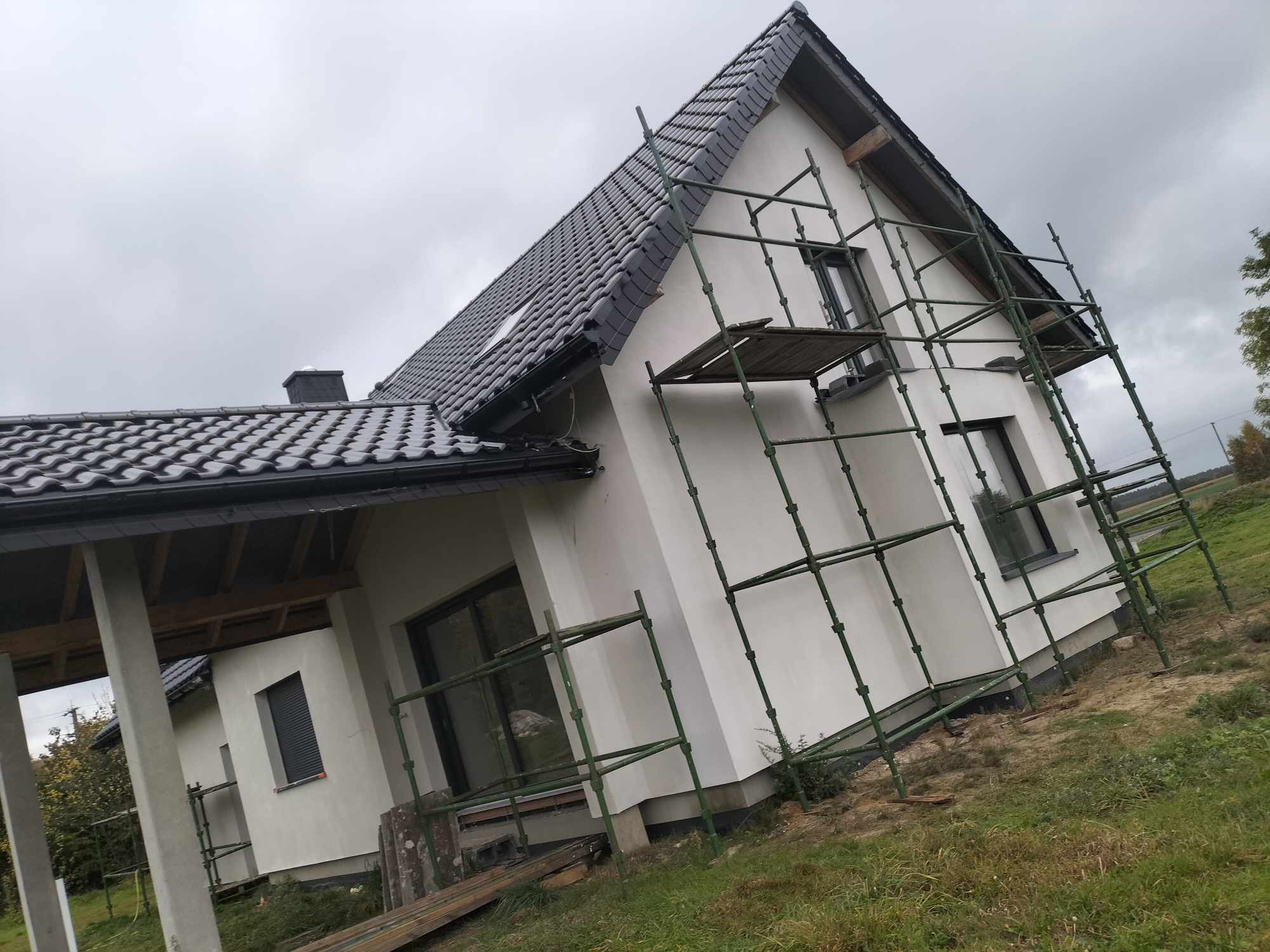 Dom jednorodzinny w Rosnowie w trakcie ocieplania elewacji, widoczne rusztowania i świeżo otynkowana ściana.