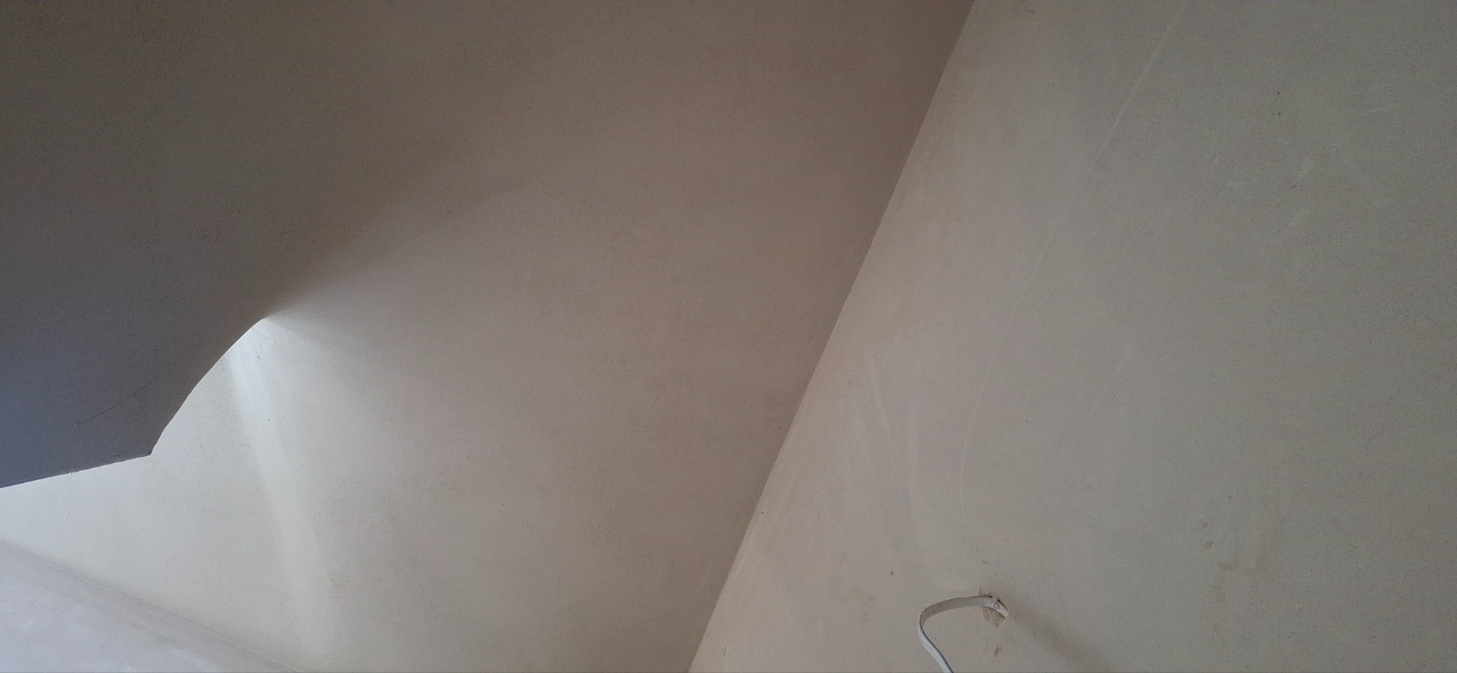 Gładka powierzchnia ściany i sufitu po nałożeniu tynku w Wysiołku Luborzyckim. Widoczny fragment instalacji elektrycznej.