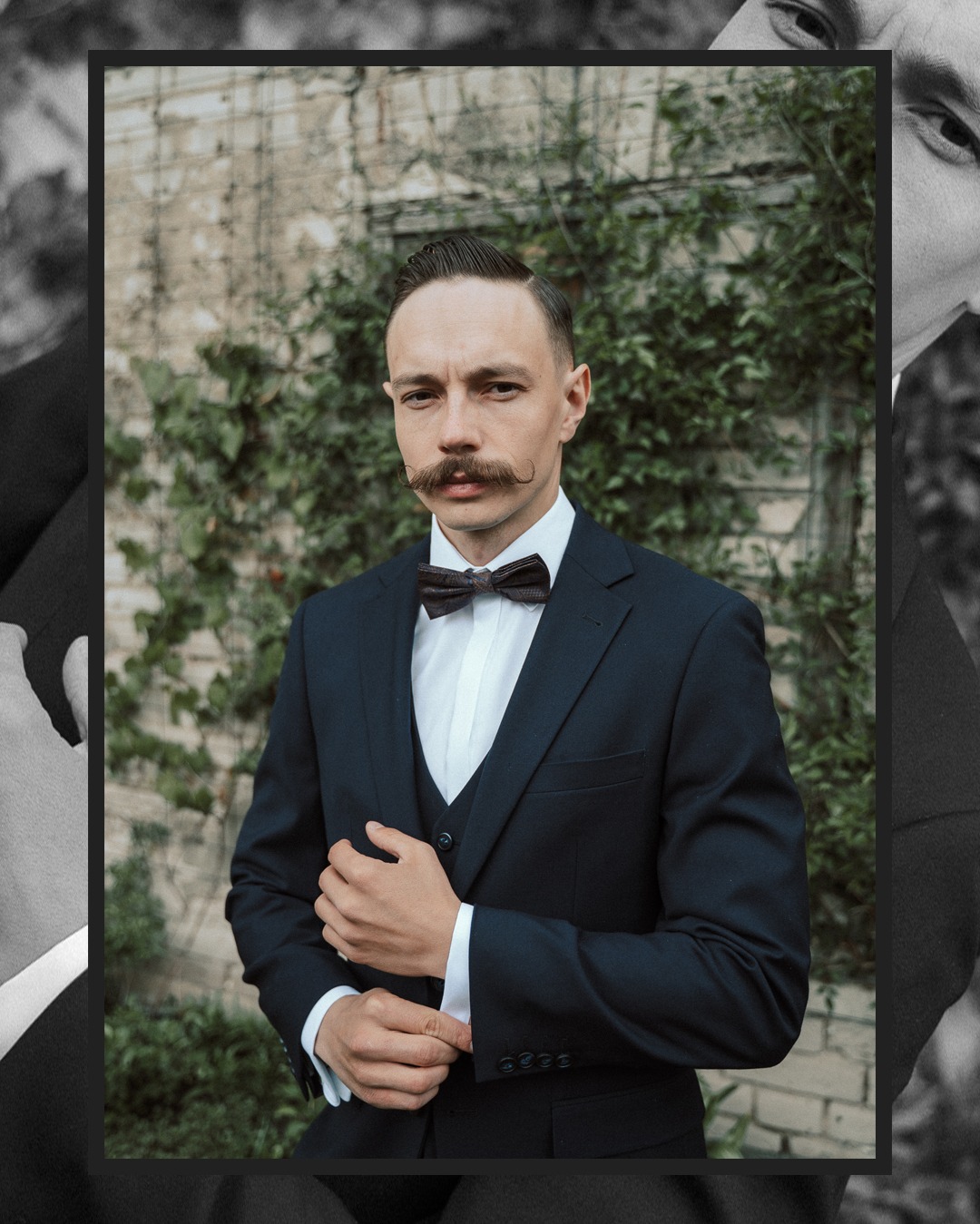 Elegancki mężczyzna z wąsami w granatowym garniturze i muszce na tle ceglanej ściany z zielenią. Portret w stylu retro.