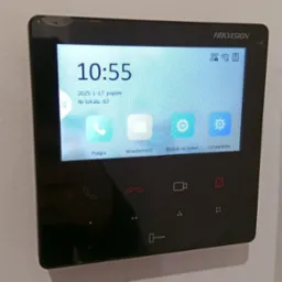 Zamontowany panel domofonu Hikvision z ekranem dotykowym, na którym wyświetlona jest godzina 10:55, data 17 stycznia 2025 i numer lokalu 83.