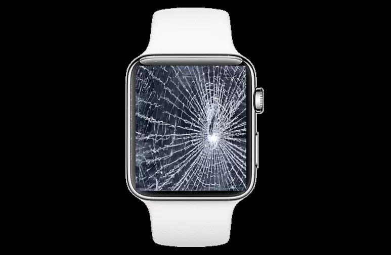 Smartwatch z białym paskiem i kompletnie rozbitym ekranem, widoczne liczne pęknięcia promieniście rozchodzące się od centralnego punktu uderzenia.