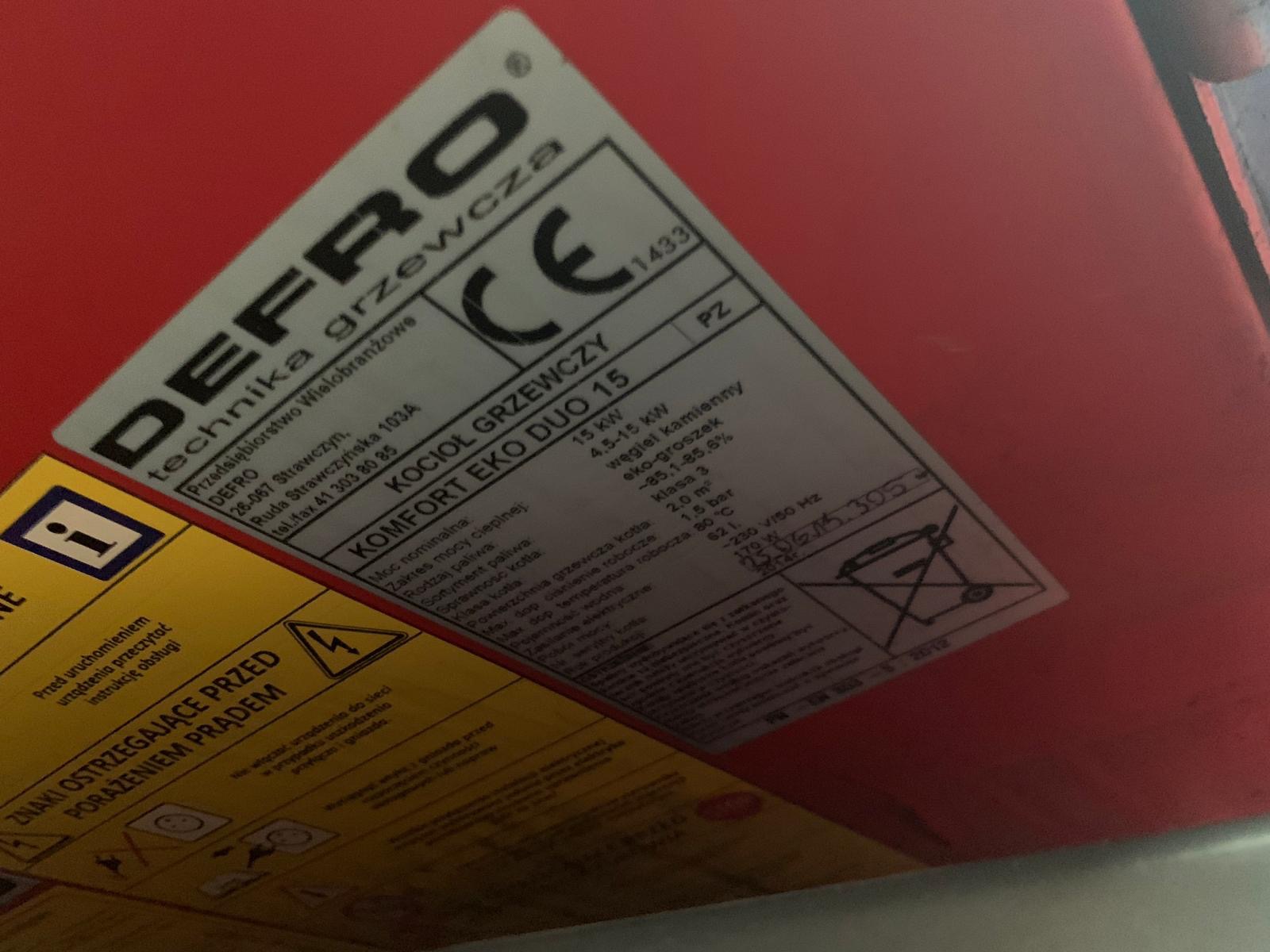 Etykieta znamionowa kotła grzewczego DEFRO Komfort Eko Duo 15, widoczne dane techniczne, moc nominalna, rodzaj paliwa, sprawność kotła, klasa kotła, oraz ostrzeżenia dotyczące bezpieczeństwa...
