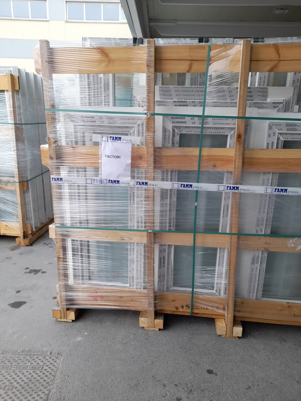 Paleta zafoliowanych okien Salamander w drewnianej skrzyni z napisem FAMM ITALIA i FACTORI