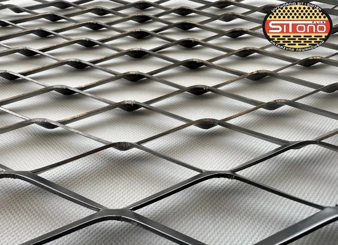 Metalowa siatka z romboidalnymi oczkami na białym tle z widocznym logo producenta w prawym górnym rogu.