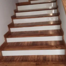 Odnowione drewniane schody z białymi podstopnicami, widok z dołu, naturalne oświetlenie.