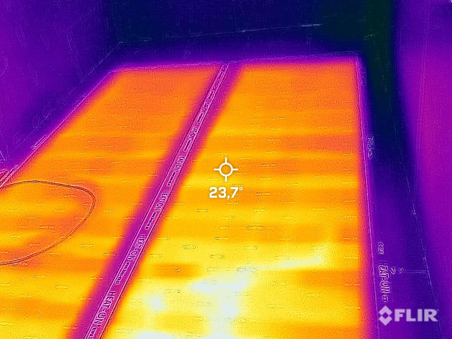 Termowizyjne zdjęcie podłogówki w trakcie działania, widoczne przewody grzewcze HEAT-ON i temperatura 23,7 stopni Celsjusza.